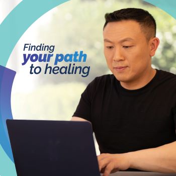 A Veteran typing on their laptop, overlaid with the message 'Finding your path to healing.' 