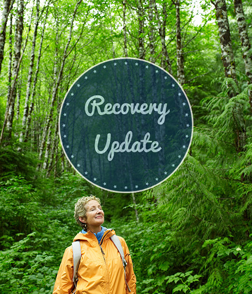 The cover of Recovery Update newsletter: A elder woman takes a deep breath in a forest.