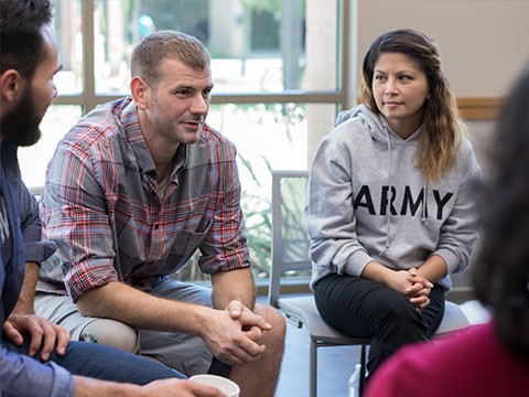 A youong male community provider runs a group therapy.