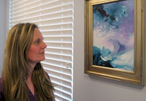 Alexandria Vet Center Counselor Narda Saunders admires a painting presented to her by one of her Veteran clients.