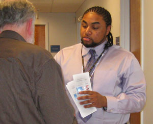 Veteran and Outreach Specialist Domonicque Tatum provides Vet Center brochures and information to a male Veteran looking for assistance.