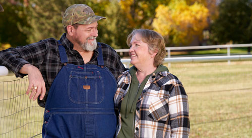 An older couple smiling at each other.