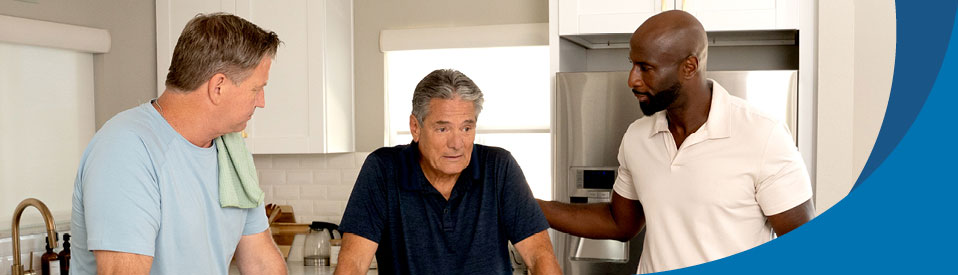 three men talking in kitchen